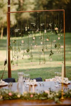 the table is set up with flowers and greenery for an outdoor wedding reception in the park