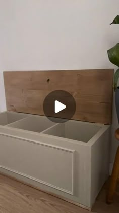 a wooden bench sitting next to a potted plant on top of a hard wood floor