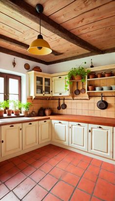 a kitchen with white cabinets and red tile flooring