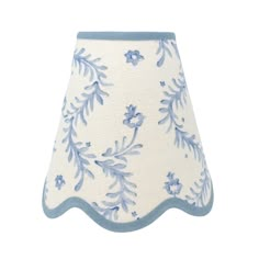 a blue and white lamp shade with flowers on it's side, against a white background