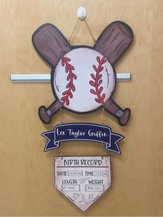 a baseball themed door hanger on a wooden door with two signs attached to it