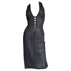 A fabulous bodycon dress in black silk eyelet by Gianni Versace Couture. It has a plunging neckline with lacing and straps crossing at the upper back. The dress has flattering seaming cutting in along the sides of the waist. It is unlined, has some stretch and an invisible side zipper. Fits sizes Small, Medium. Bust 34-36" Waist 28-30" Hips 37-39" Length 39" Gianni Versace Dress, Laceup Dress, Plunge Bodycon Dress, Plunging Neckline Dress, Lace Up Back Dress, Asymmetrical Black Dress, Plunging Neck Dress, Versace Dress, Versace Couture