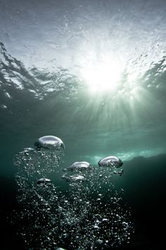 the sun shines through the water as it peeks out from under the surface