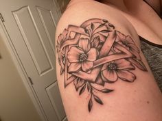 a woman with a tattoo on her arm has flowers and a ribbon in the shape of a heart