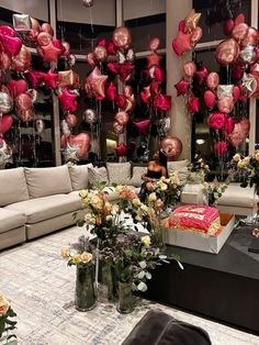 a living room filled with lots of furniture and balloons