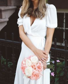 a woman in a white dress holding a bouquet of flowers