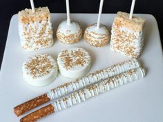 cake pops with white frosting and gold sprinkles are arranged on a platter