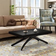 a living room with a couch, chair and coffee table in front of large windows