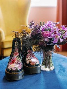 purple flowers in boots on a blue table cloth