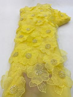 a yellow dress with flowers on it and sequins in the center is shown