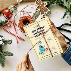 a person holding a book in their hands next to christmas decorations and other holiday items