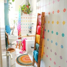 a bathroom with a ladder in the middle of it and colorful decor on the walls