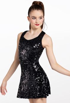 a woman in a black sequin dress posing for the camera with her arms outstretched