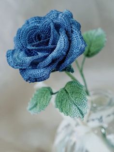 a blue rose sitting in a glass vase