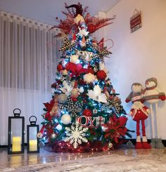 a decorated christmas tree in the corner of a room with two stuffed animals on it