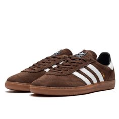 Caractéristiques de la Adidas Samba Deco SPZL Brown La Adidas Samba Deco SPZL Brown est une réinterprétation élégante et raffinée de la Samba, revisitée dans le cadre de la collection Adidas Samba. Habillée d'un riche coloris marron en suède de haute qualité, cette Adidas Samba marron se distingue par ses trois bandes blanches iconiques et son talon blanc, ajoutant un contraste saisissant qui rehausse son allure classique. Le logo "SAMBA SPZL" en doré sur le côté ajoute une touche d'exclusivité Sneaker Trends, Mens Shorts Outfits, Low Air Jordan 1, Pretty Shoes Sneakers, Adidas Spezial, Minimalist Shoes, Nike Dunk High, Adidas Fashion, Adidas Campus