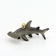 a shark shaped ring with two gold rings on it's back end, sitting in front of a white background