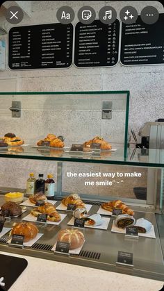 a display case filled with lots of different types of bread and pastries on plates