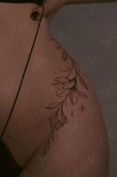 the back of a woman's stomach with leaves on it and an arrow tattoo