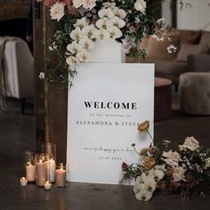 a welcome sign surrounded by flowers and candles