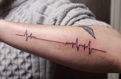 a man's arm with a heartbeat tattoo on it