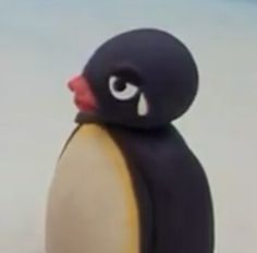 a toy penguin with big eyes and an orange beak