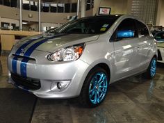 a silver car with blue stripes parked in a garage