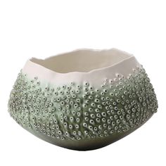 a white and green bowl with holes in it