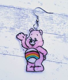 Cheer bear is here to brighten your day! This is an adorable earring set featuring cheer bear! She is pink with a rainbow on her stomach! You get one cheer bear and one rainbow. *Hand drawn and painted *Hand made from start to finish. *Sterling silver hooks. 925 surgical sterling silver. *Super light and comfortable. *Earrings are sealed but extended time in the water such as swimming or showering is not recommended. *Items usually ship within 3 to 5 business days *Special requests are always we Comfortable Earrings, Shrinky Dink Earrings, Cheer Bear, Bear Earrings, 80s Cartoon, Mismatched Earrings, Care Bear, Business Inspiration