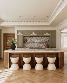 a kitchen with marble counter tops and white stools in front of an island that has four vases on it