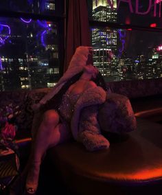 a woman sitting on top of a table with a teddy bear in front of her