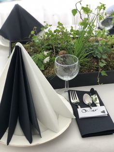 the table is set with black and white napkins, place settings, and silverware