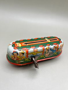 a small tin with an image of children on it and a screwdriver next to it