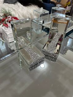 a mirrored table topped with lots of glass boxes