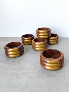 six wooden bowls with gold rings on them