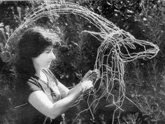 an old photo of a woman working with wire