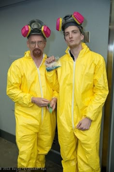 two men in yellow suits are standing next to each other wearing gas masks and goggles