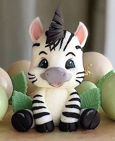 a zebra figurine sitting on top of a table next to some green eggs