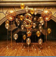 balloons and streamers in the shape of a letter s are hanging from a ceiling