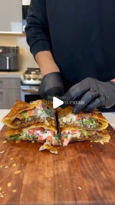 a person cutting up food on top of a wooden cutting board