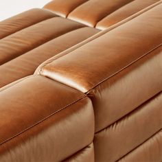 the back end of a brown leather couch with two reclinings on top of it