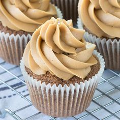 several cupcakes with frosting on a cooling rack