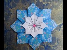 an origami flower on a blue and white background with the words lidane 52 below it