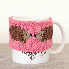 a knitted coffee cup cozying in pink and brown with an owl on it