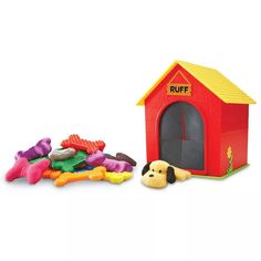 a red dog house next to a pile of toys