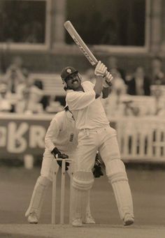 a black and white photo of a man playing cricket