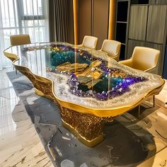 a glass table with gold and purple decorations on it in front of a large window