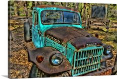 an old rusty blue truck parked in the woods