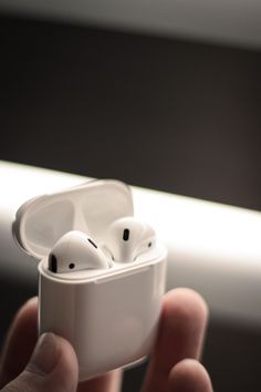 a person holding an apple airpods in their hand