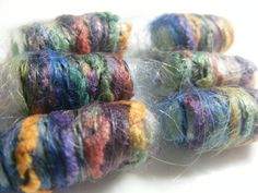 four skeins of multicolored yarn sitting on top of each other